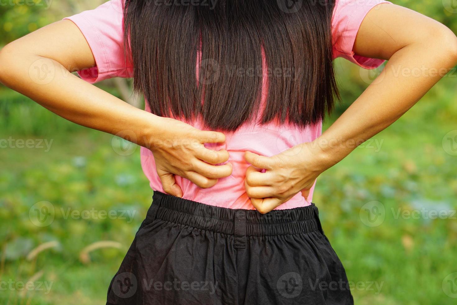 parte traseira do conceito de dor e dor nas costas da mulher branca, mulher asiática com coceira nas costas foto