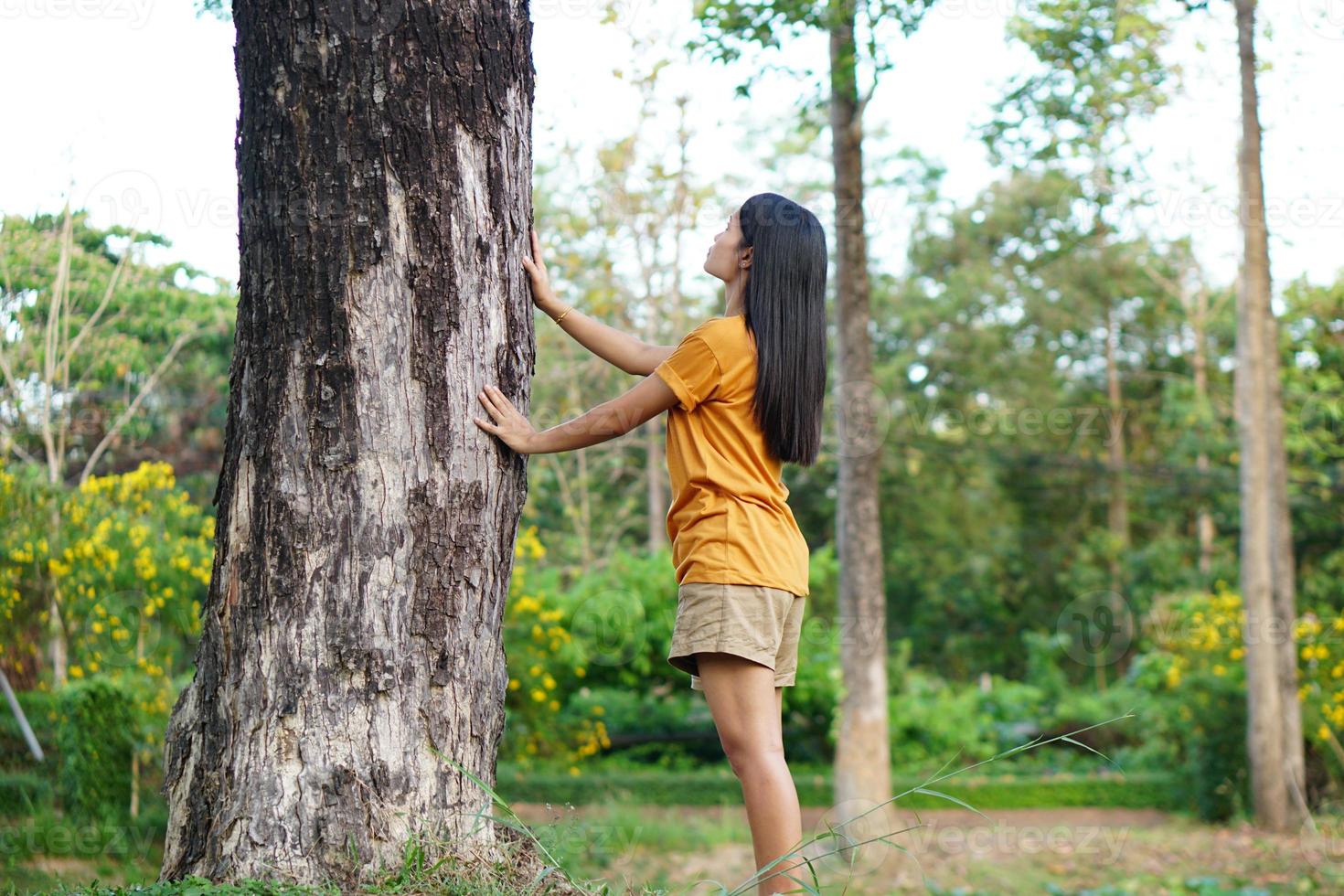 mulheres asiáticas abraçando árvores, o conceito de amor pelo mundo foto