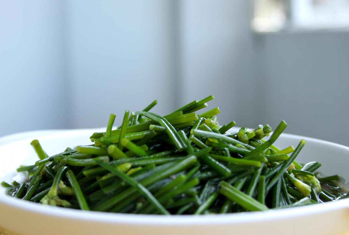 mexa flores de cebolinha chinesa frita no prato branco e desfoque o fundo. foto