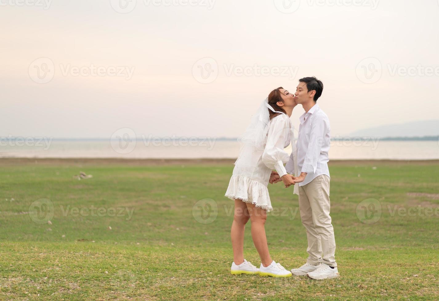 feliz jovem casal asiático em roupas de noivos foto