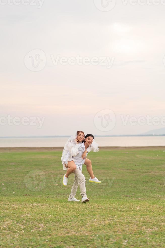 feliz jovem casal asiático em roupas de noivos foto