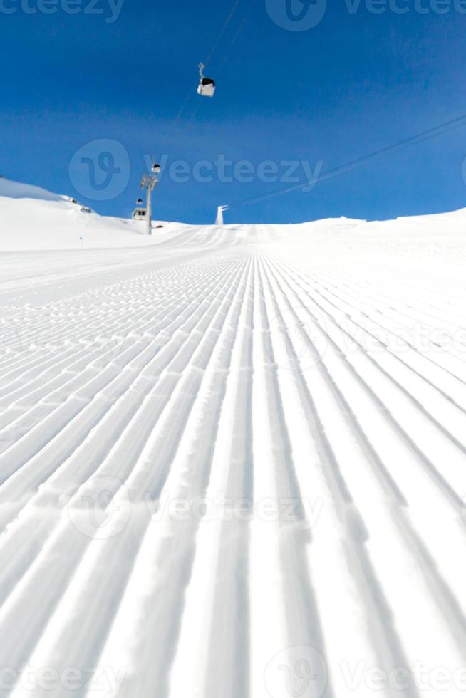 pista de esqui recém-preparado em um dia ensolarado foto