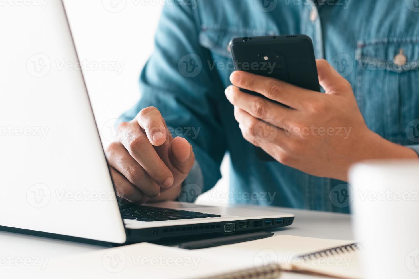 trabalho usando telefone celular digitando computador laptop de bate-papo móvel entre em contato conosco em locais de trabalho, planejando ideias investidores pesquisando na internet, ideias conectando pessoas. foto