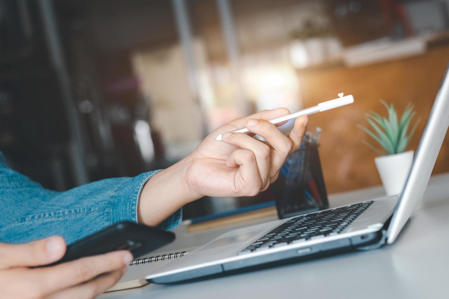 trabalho usando telefone celular digitando computador laptop de bate-papo móvel entre em contato conosco em locais de trabalho, planejando ideias investidores pesquisando na internet, ideias conectando pessoas. foto