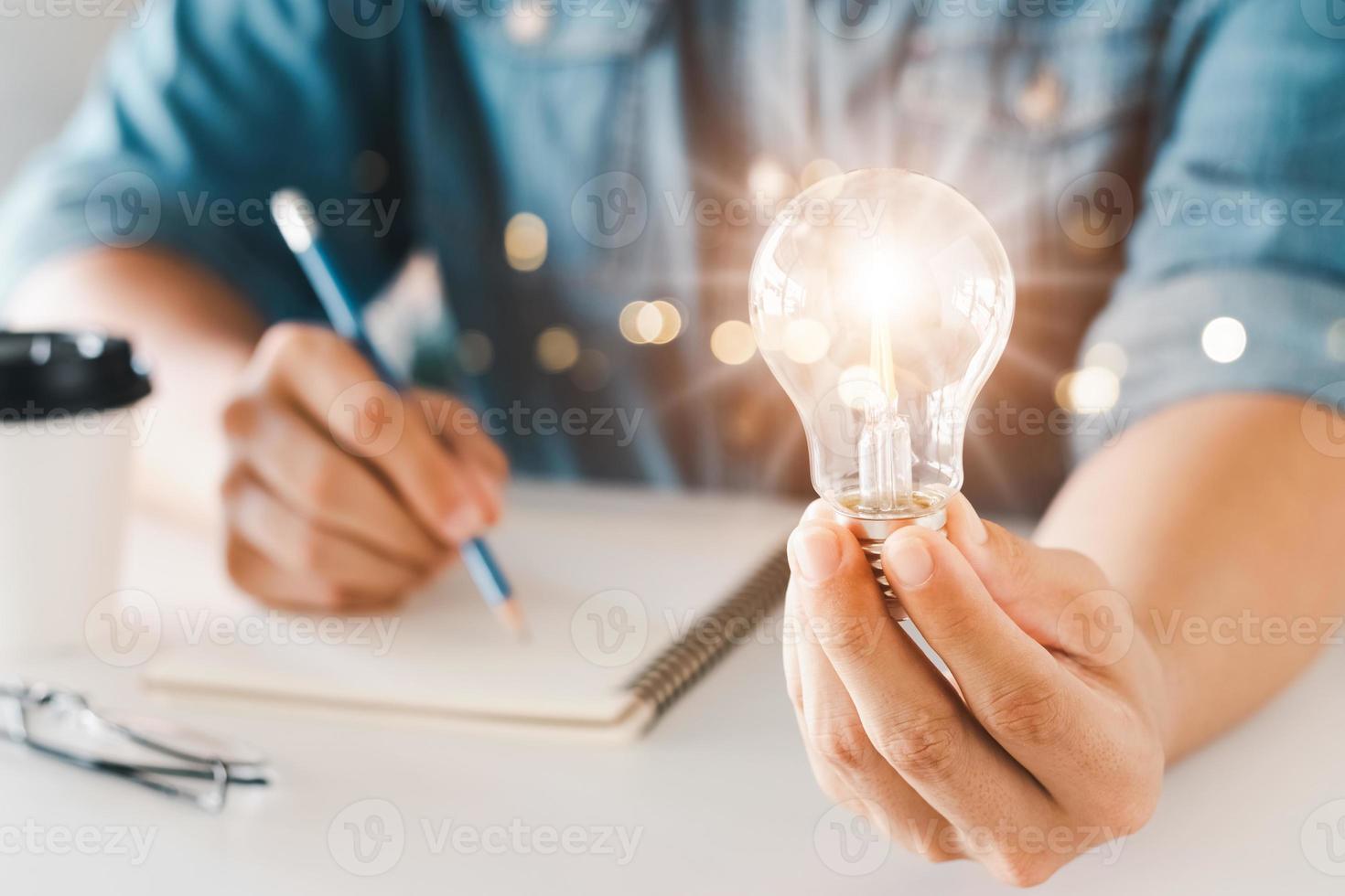 inovação através de ideias e ideias de inspiração. mão humana segurando a lâmpada para iluminar, ideia de criatividade e conceito de inspiração de desenvolvimento de negócios sustentáveis. foto