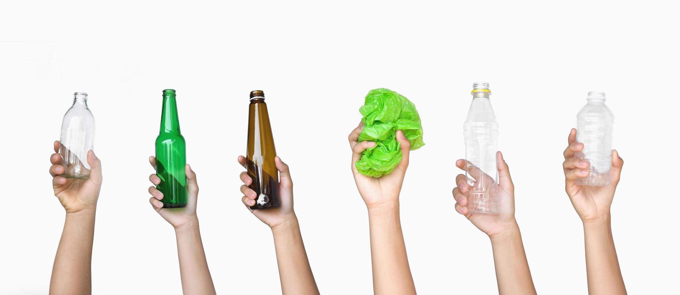 mão segurando lixo de vidro de garrafa e garrafa de plástico com saco plástico isolado no fundo branco foto