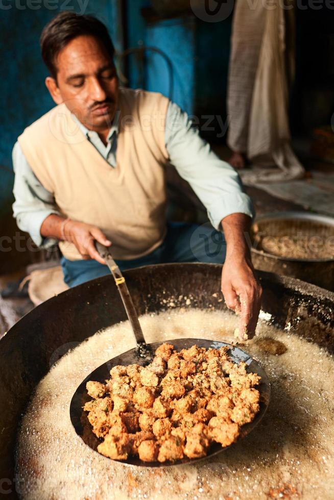 vendedor de rua indiano preparando comida foto