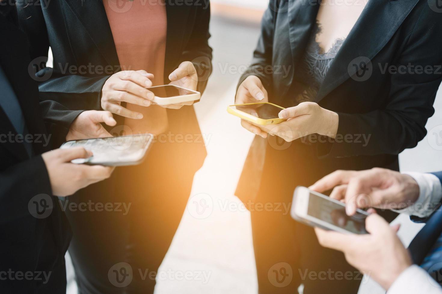 grupo de jovens empresários em pé e usando smartphone juntos comunicação de conceitos. foto