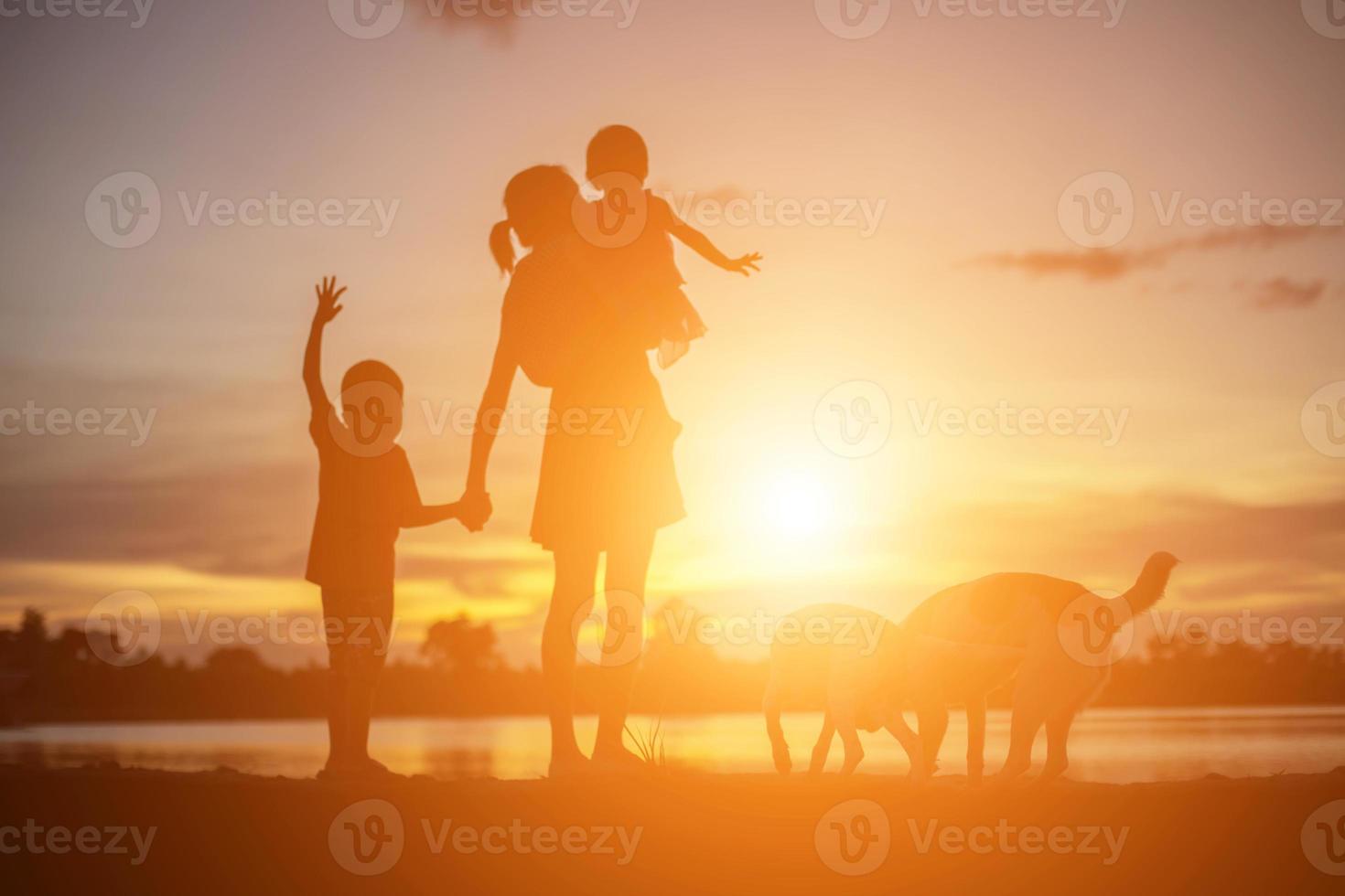 mãe incentivou seu filho ao ar livre ao pôr do sol, conceito de silhueta foto