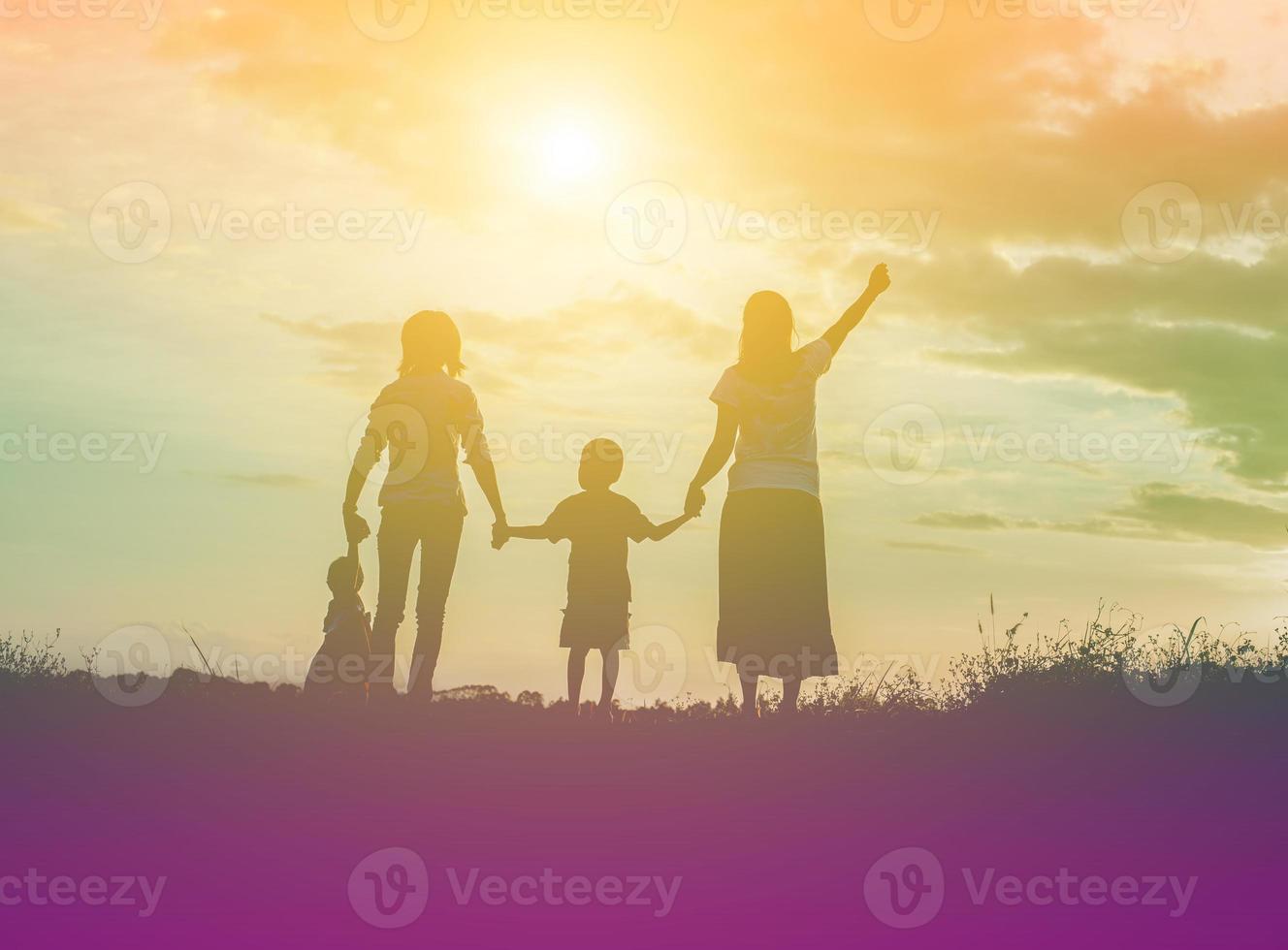 família feliz dançando na estrada na hora do pôr do sol. festa noturna na natureza foto