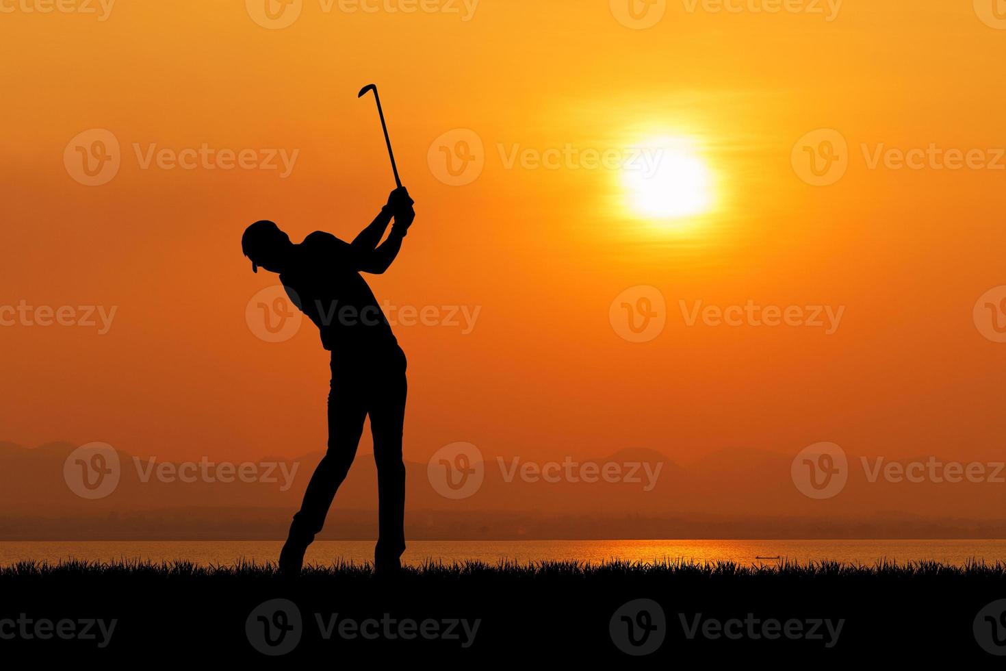 silhueta de jogador de golfe contra o pôr do sol foto