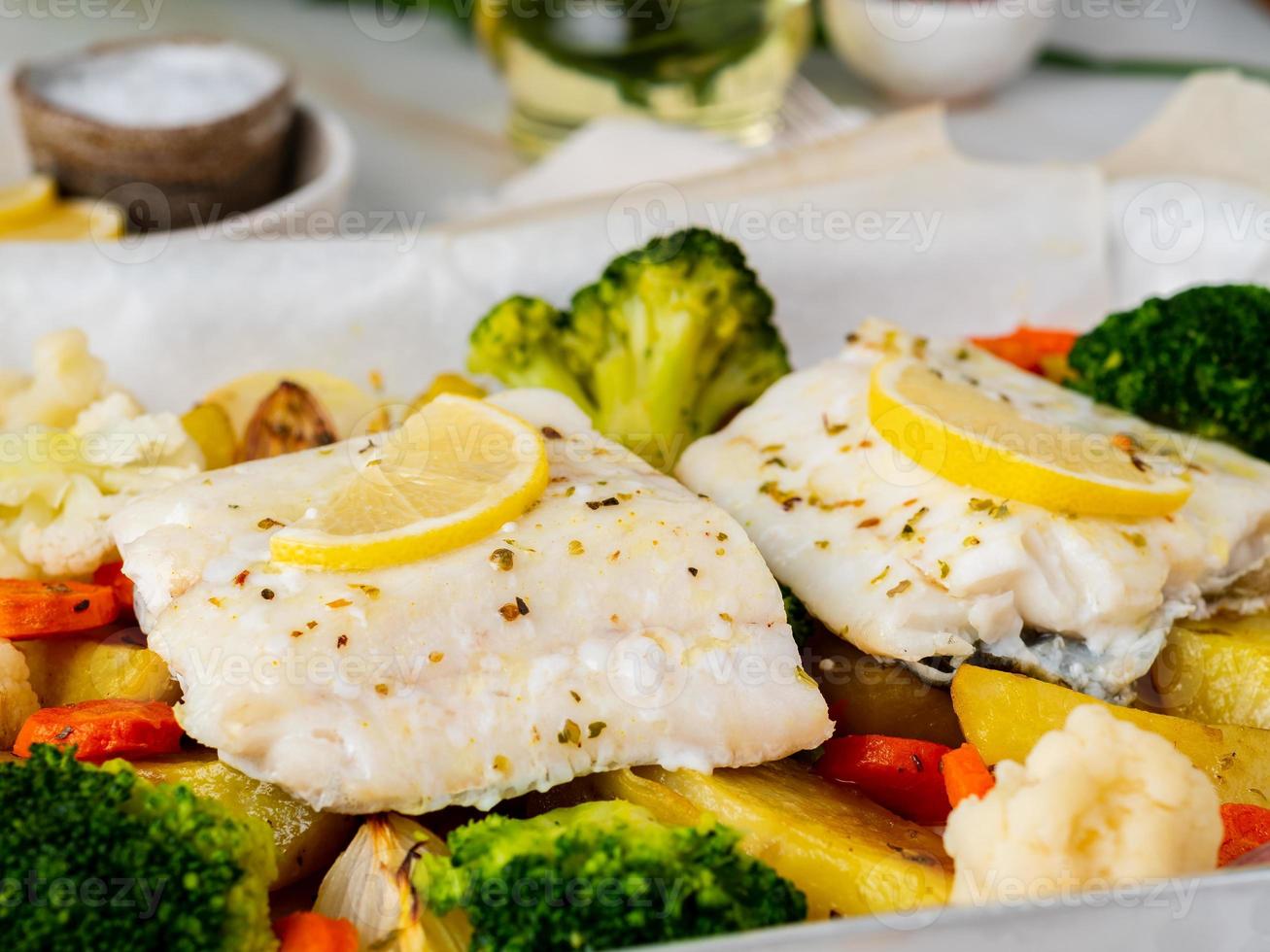 bacalhau de peixe assado com legumes - alimentação saudável dieta saudável. mármore branco claro foto
