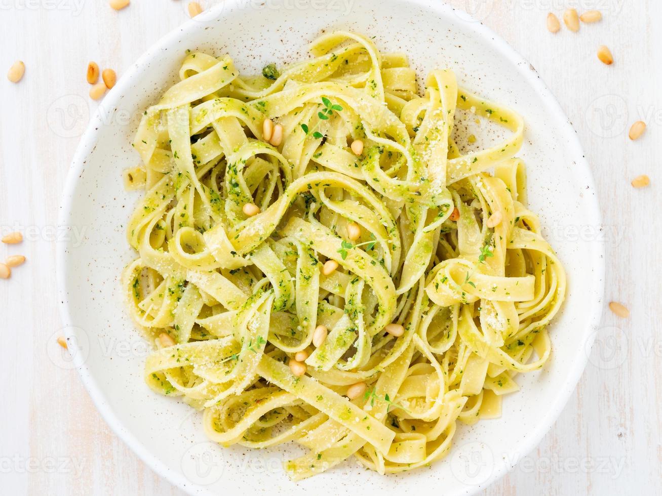 massa tagliatelle com molho pesto feito de manjericão, alho, pinhões, azeite foto