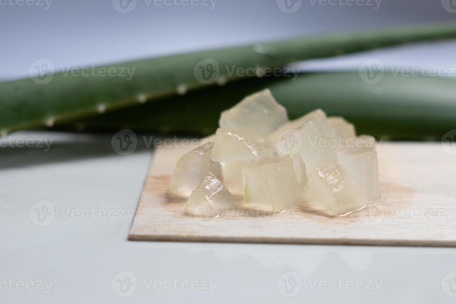 gel de aloe vera na placa de madeira e fundo branco, planta cosmética da pele, tratamento antibiótico tópico. foto