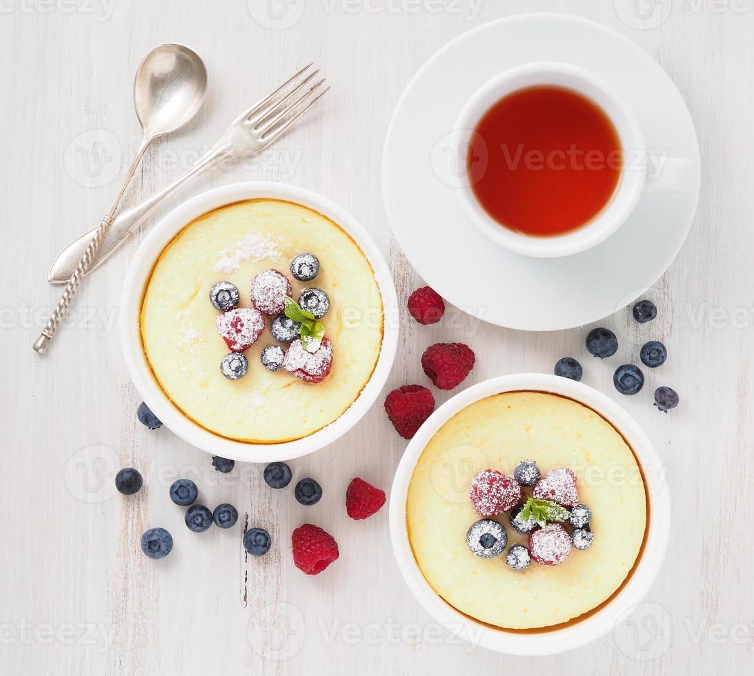 cheesecake decorado com framboesas, mirtilos e hortelã em dois ramekin, deliciosa sobremesa foto