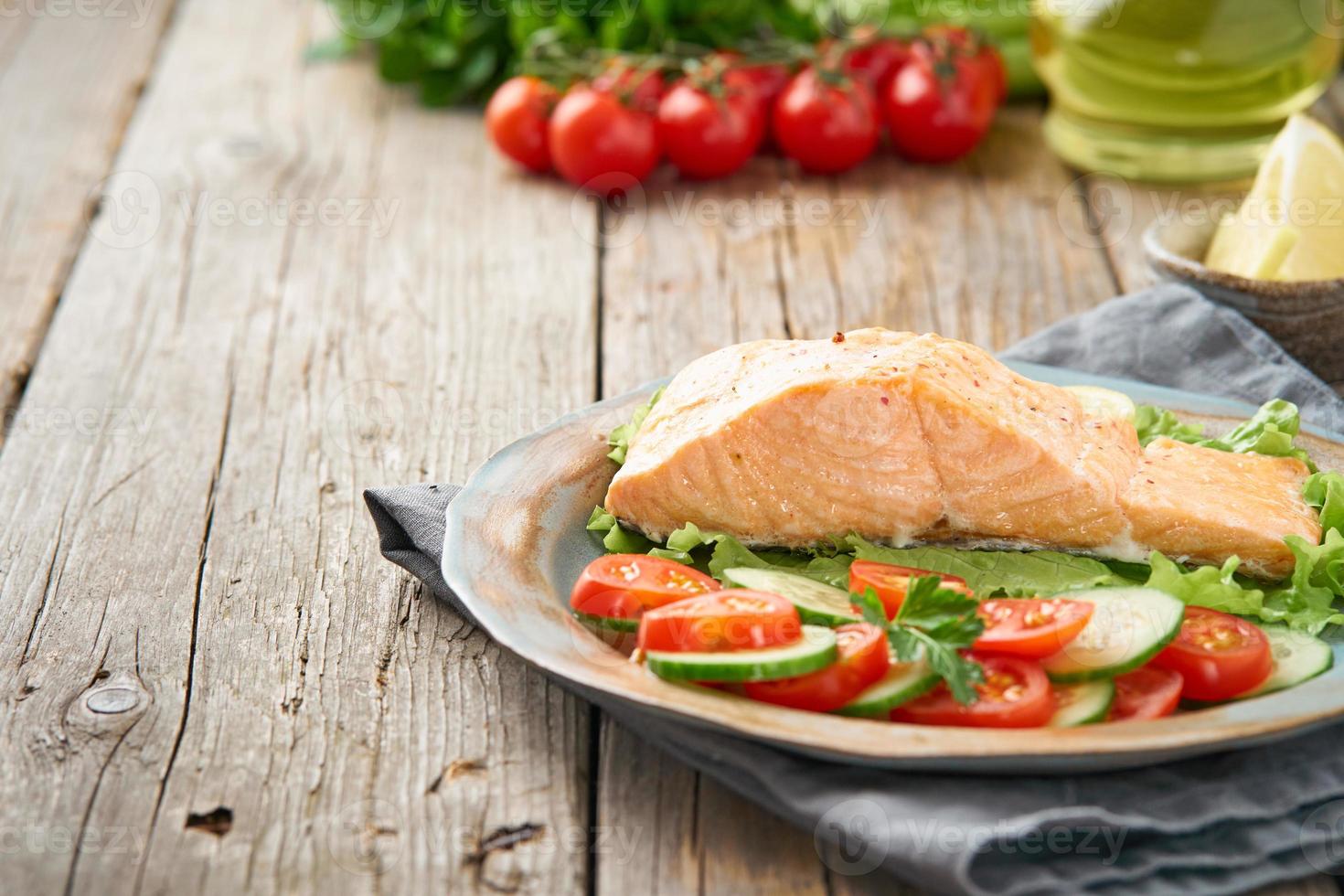 salmão e legumes a vapor, paleo, ceto, dieta fodmap. vista lateral. conceito de dieta saudável, placa azul na velha mesa de madeira rústica foto