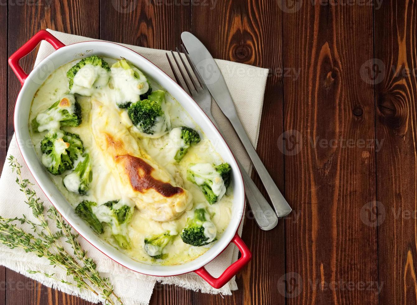 filé de frango assado com brócolis em molho bechamel na mesa de madeira. alimentação saudável, alimentação limpa foto