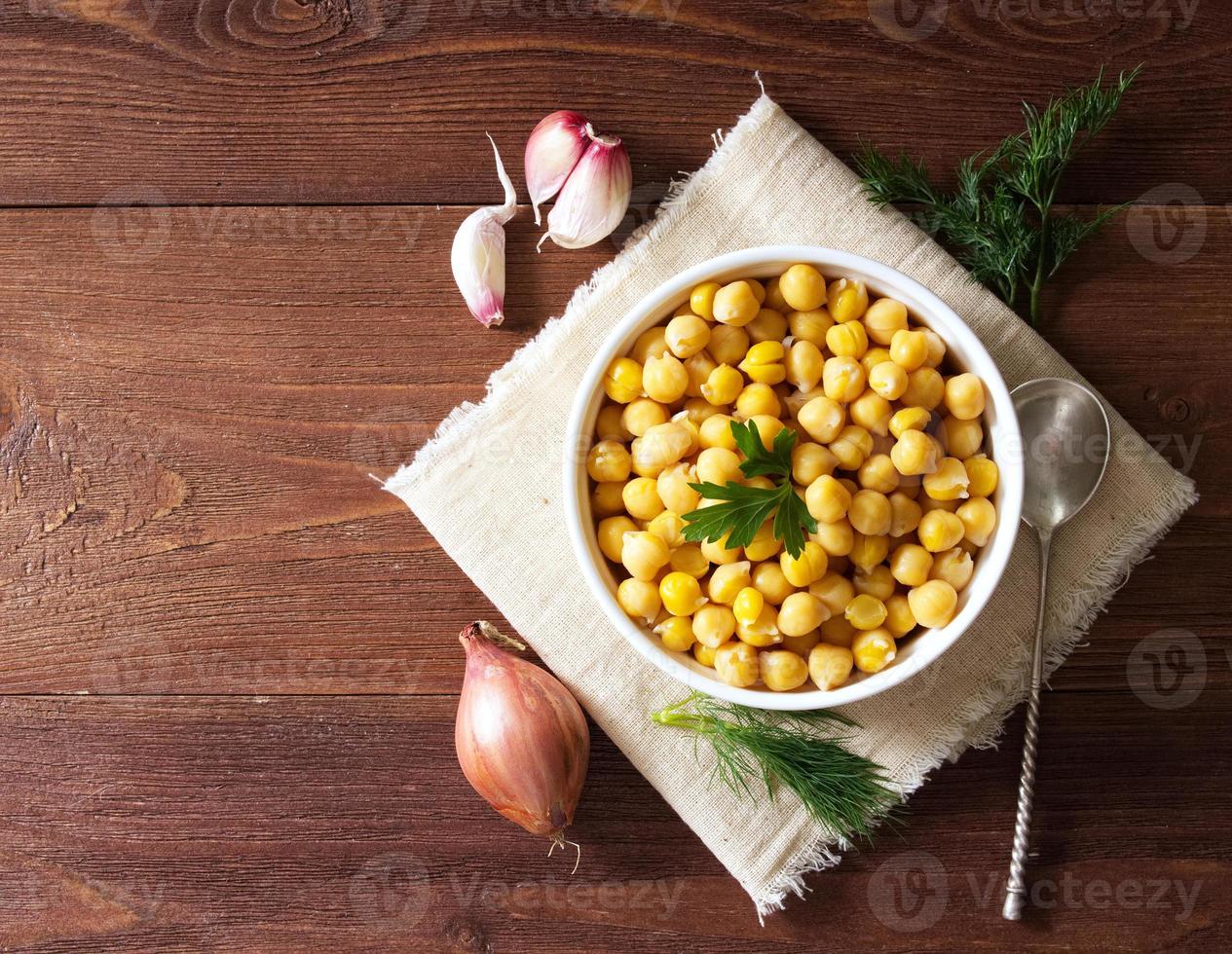 grão de bico cozido na tigela na mesa de madeira escura. saudável, vegetariano foto