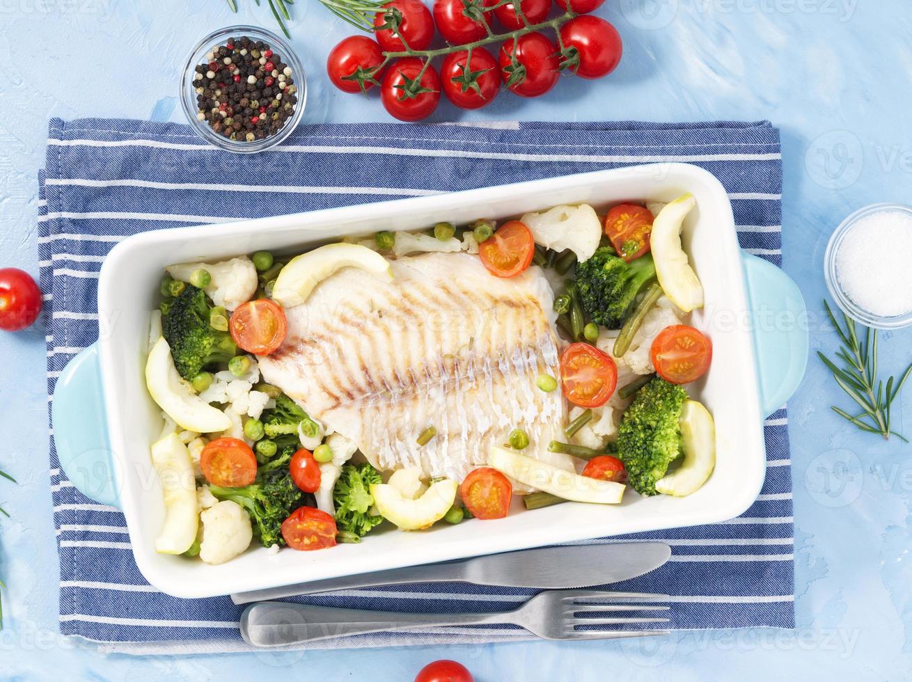 bacalhau de peixe assado no forno azul com legumes - brócolis, tomate. comida de dieta saudável. foto