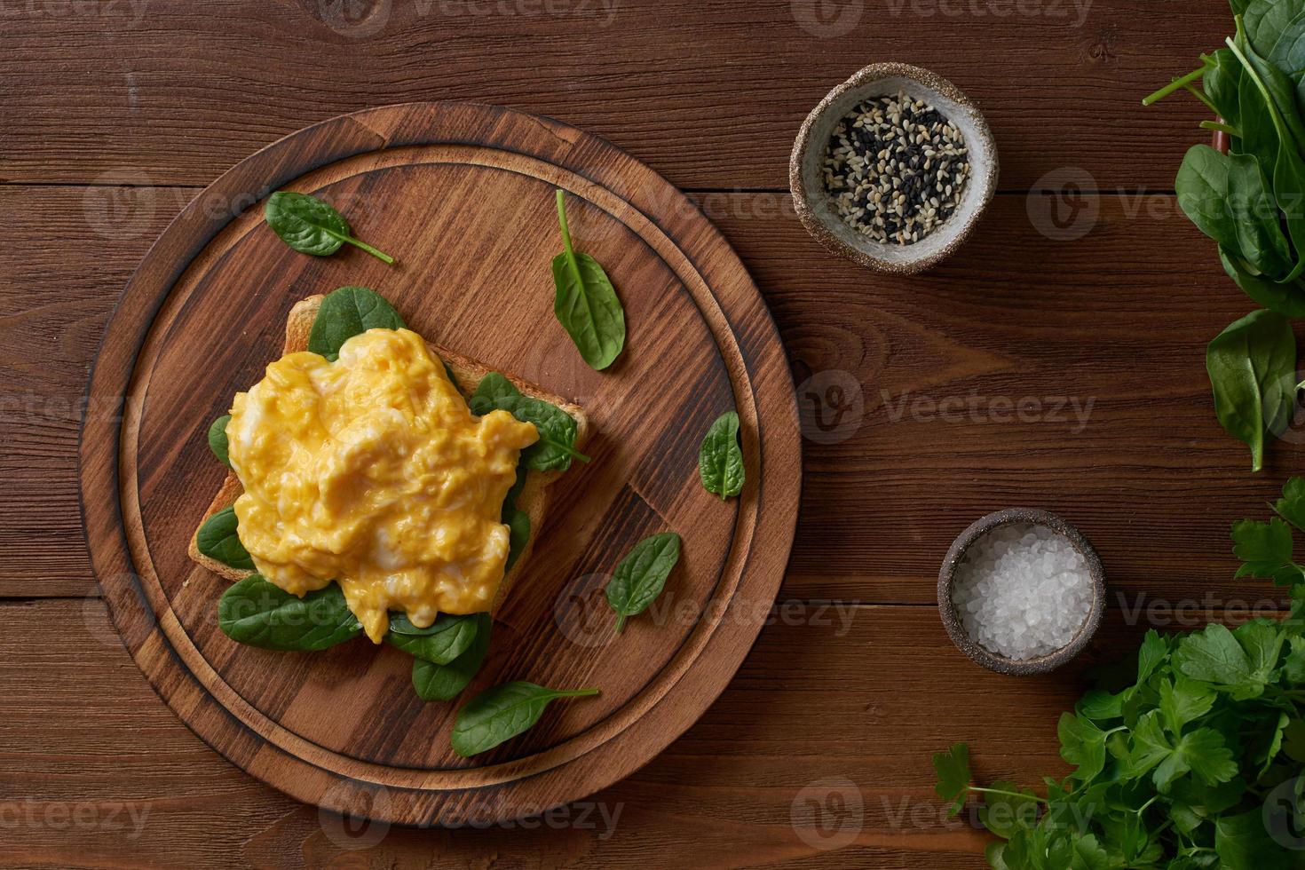 torradas com ovos mexidos e espinafre. omelete. café da manhã com ovos fritos foto