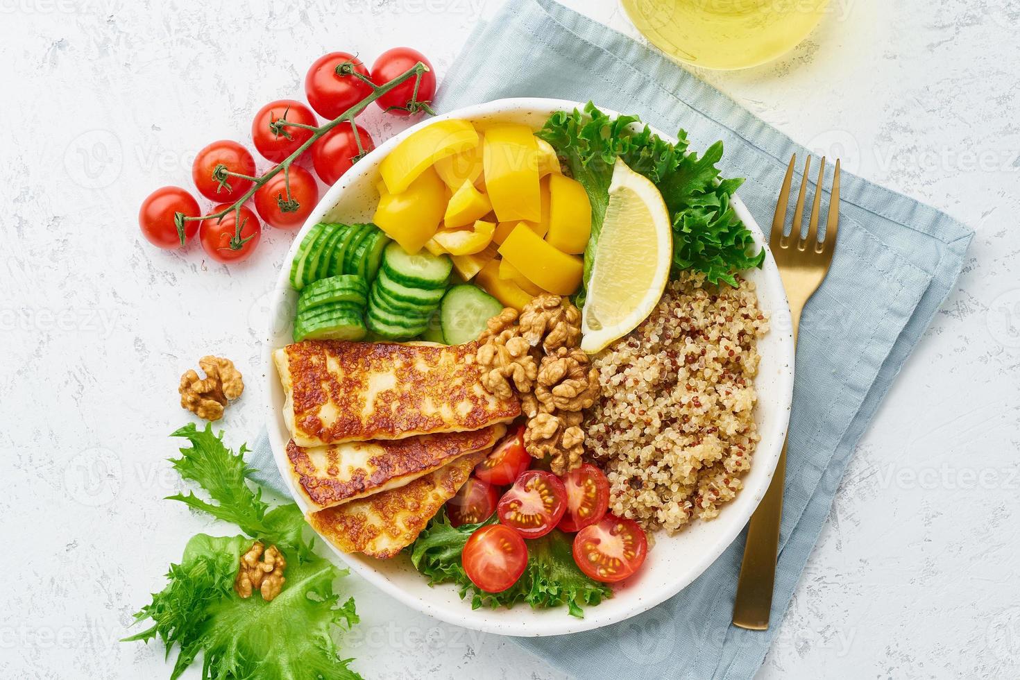 tigela de buda com halloumi, quinoa, salada de alface, comida equilibrada, fundo branco, vista superior foto