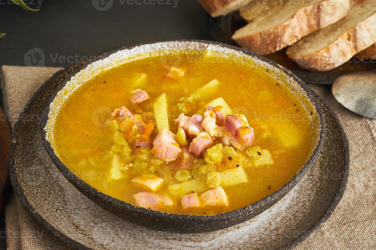 sopa quente de inverno com ervilhas verdes picadas, carne de porco, bacon, defumado na mesa de madeira marrom escura. deliciosa sopa rica em gordura apetitosa. foto