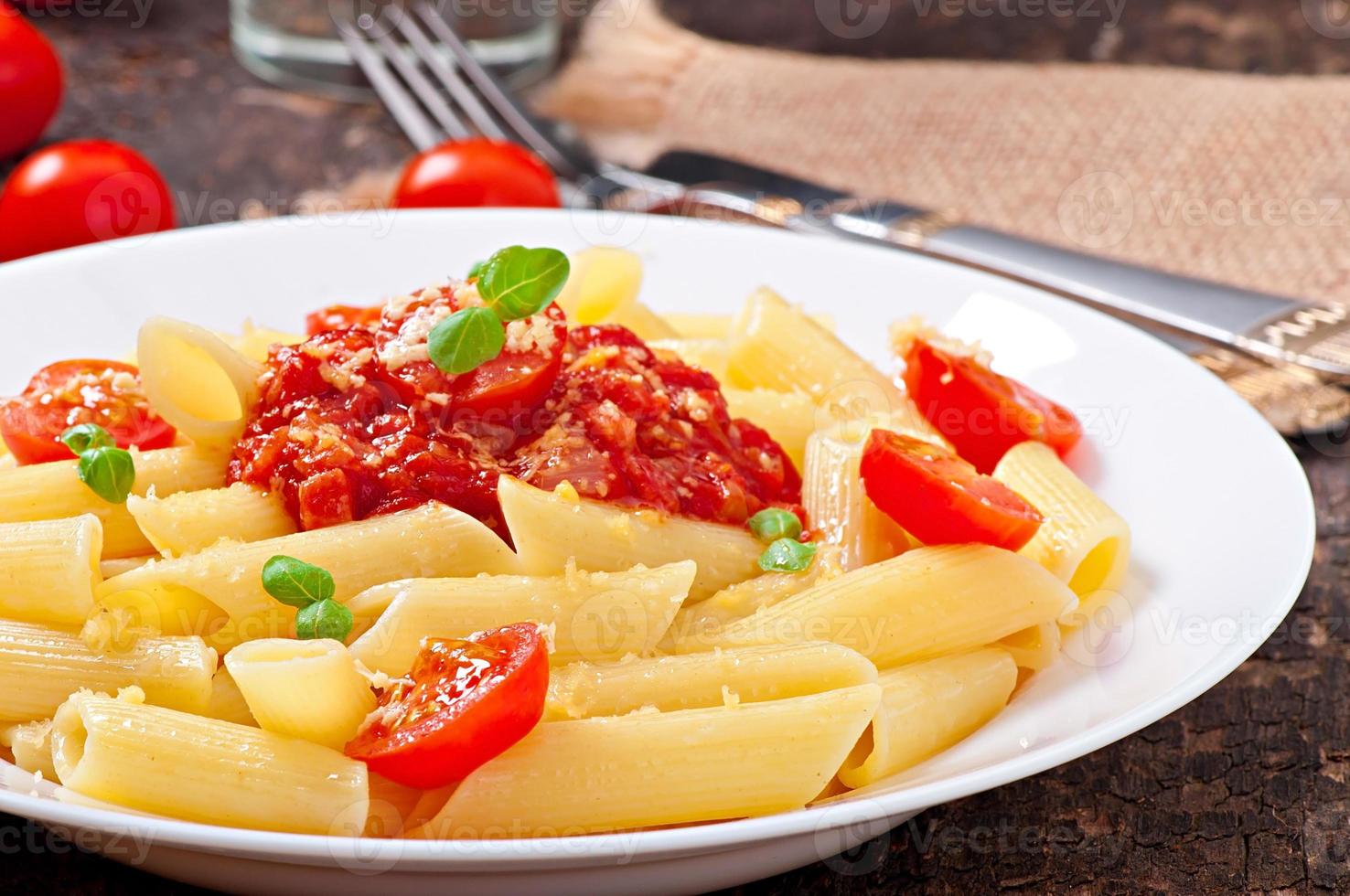 macarrão penne com molho bolonhesa, queijo parmesão e manjericão foto