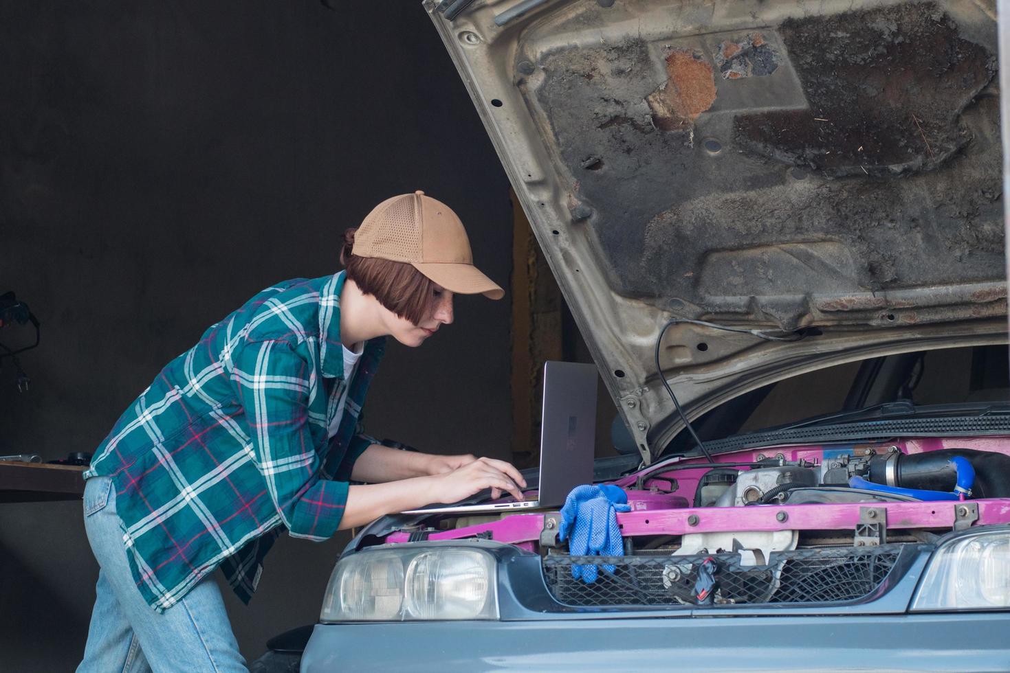 mecânico feminino consertando carro em uma garagem foto