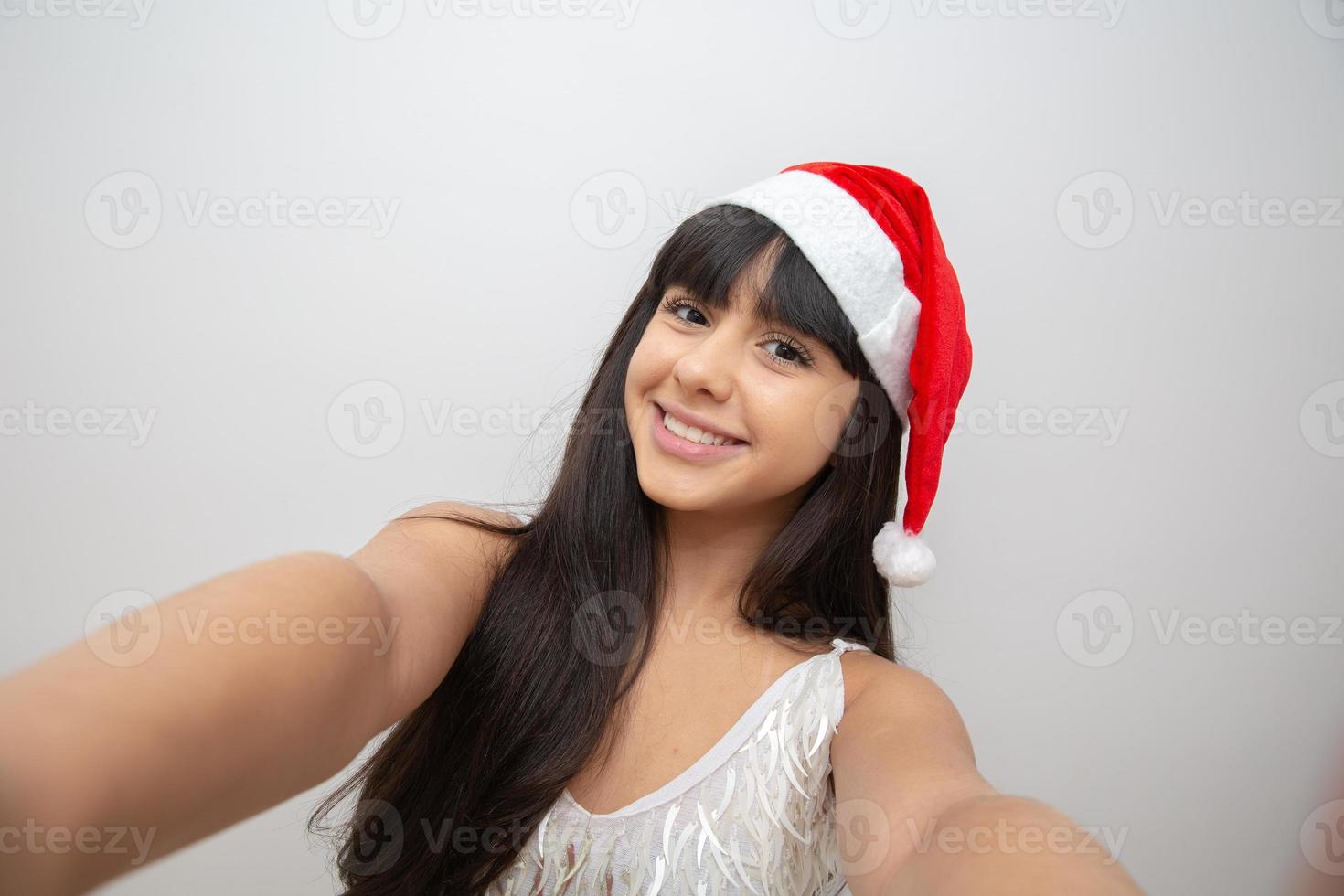 jovem puxando selfie com chapéu de papai noel foto