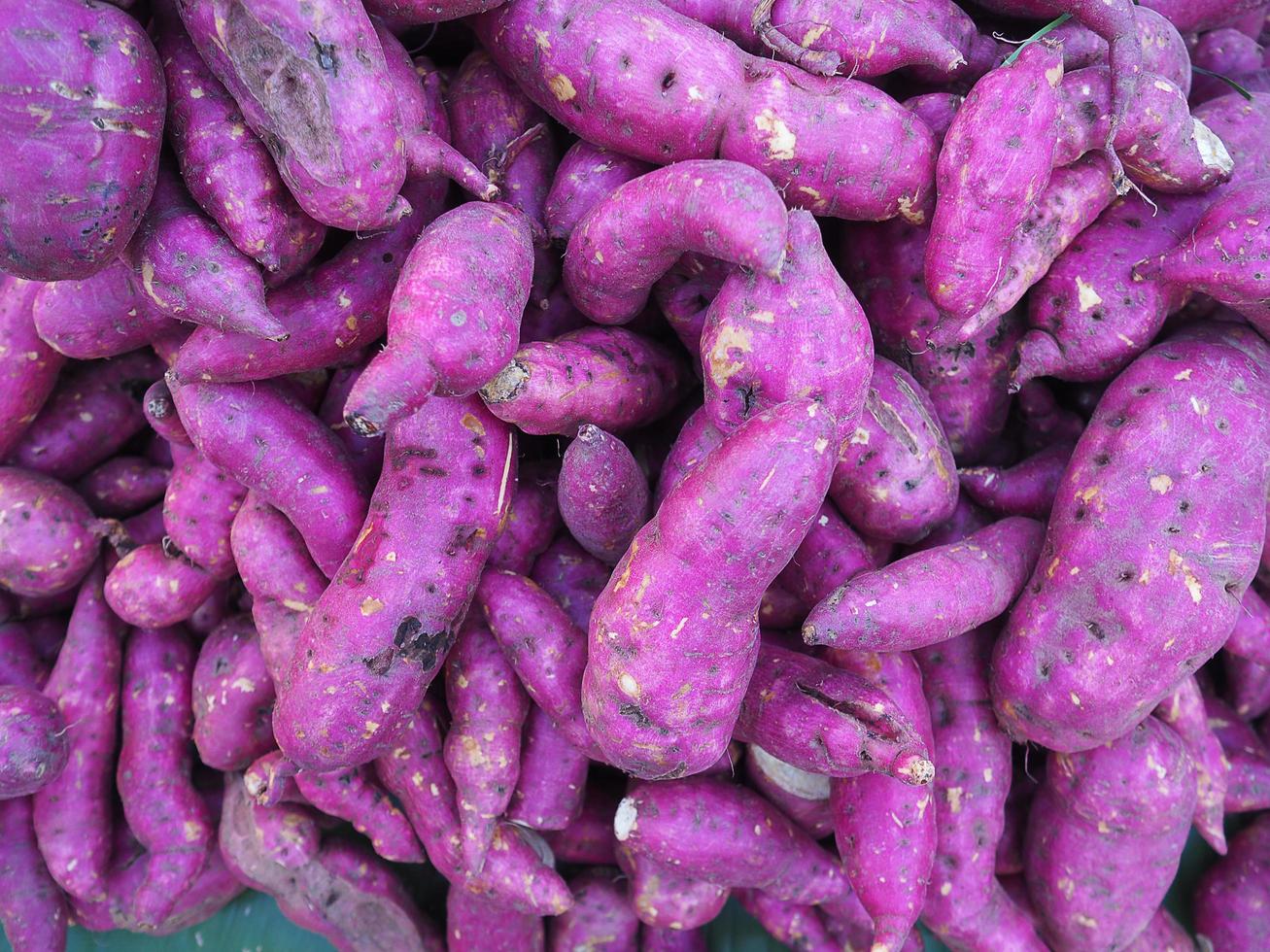 pilha de inhame roxo fresco orgânico para venda no mercado foto