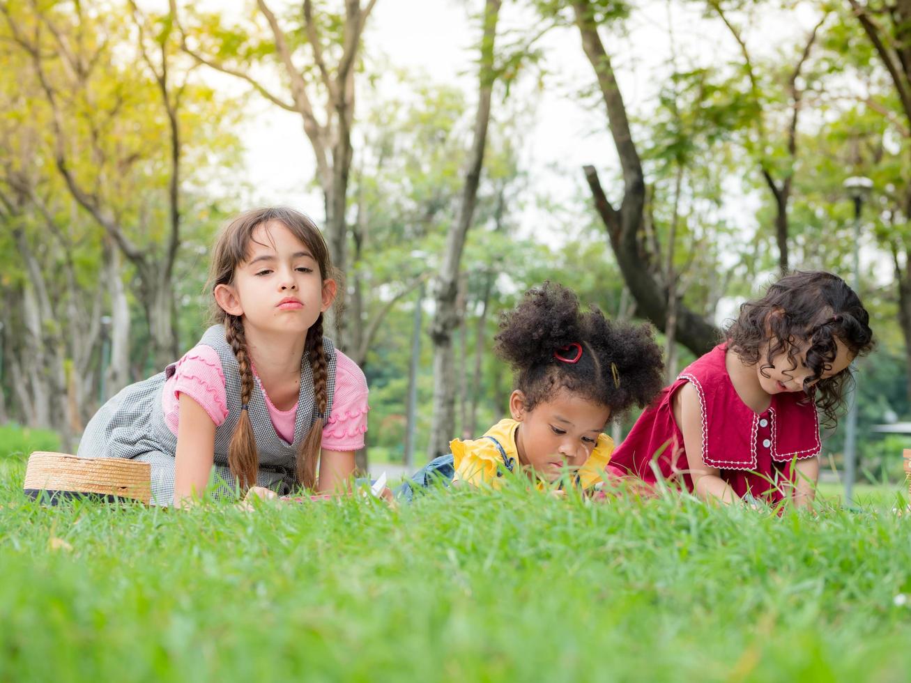 um grupo de crianças de várias nacionalidades brinca e aprende fora da escola para se divertir no parque natural foto