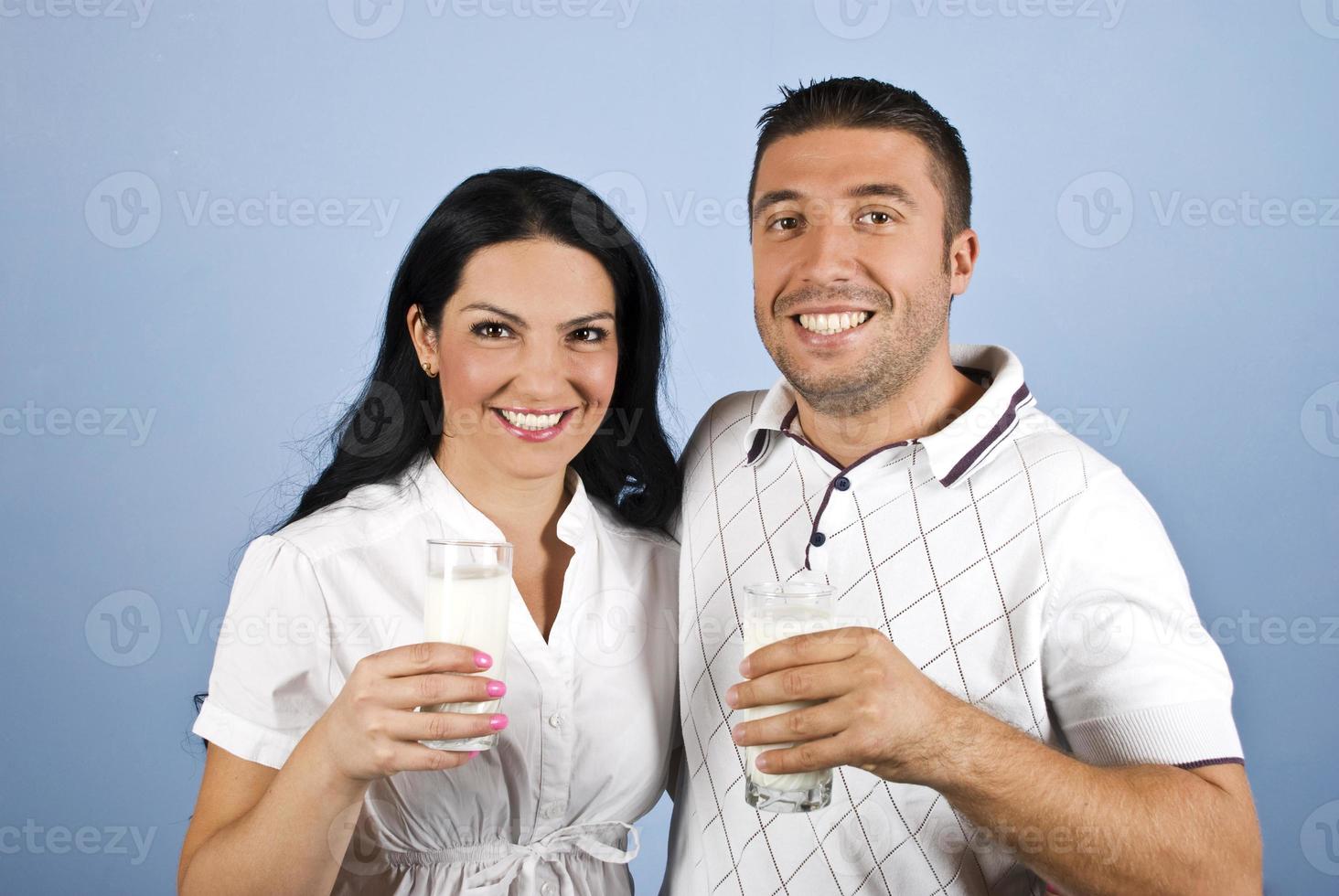 casal feliz saudável com copos de leite foto