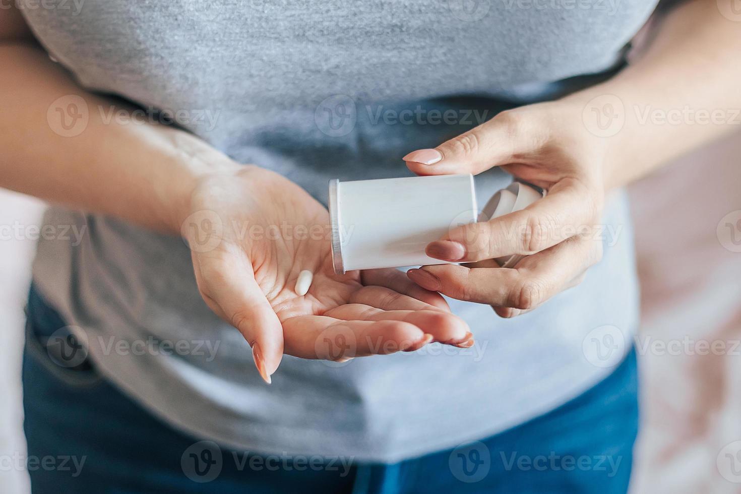 mulher está tomando pílulas. dia mundial da saúde. mãos segurando uma garrafa médica com cápsulas. conceito de cuidados de saúde. foto