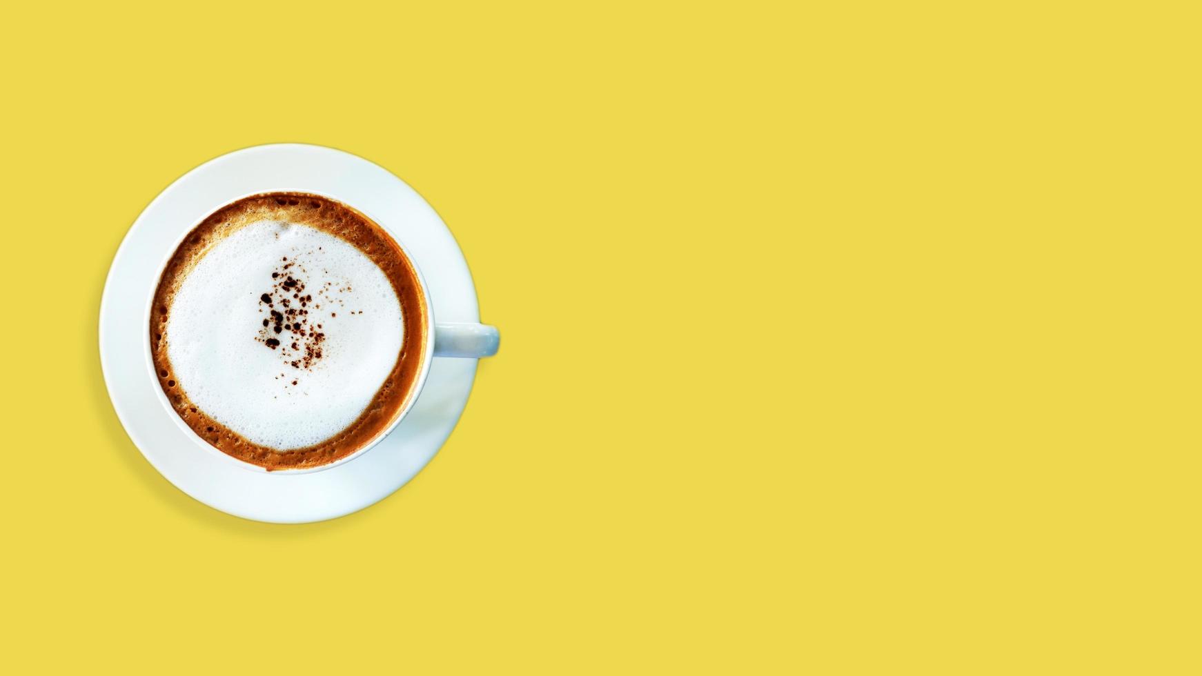 vista superior cappuccino café em fundo amarelo. foto