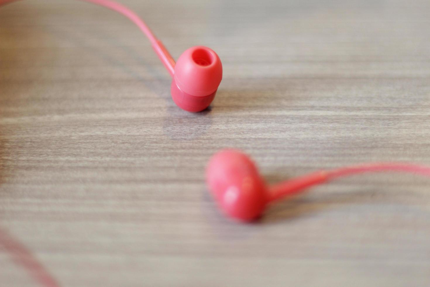 dois fones de ouvido rosa na mesa foto