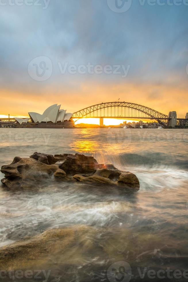 pôr do sol na ópera e ponte do porto em sydney, novo estado de gales do sul da austrália. foto