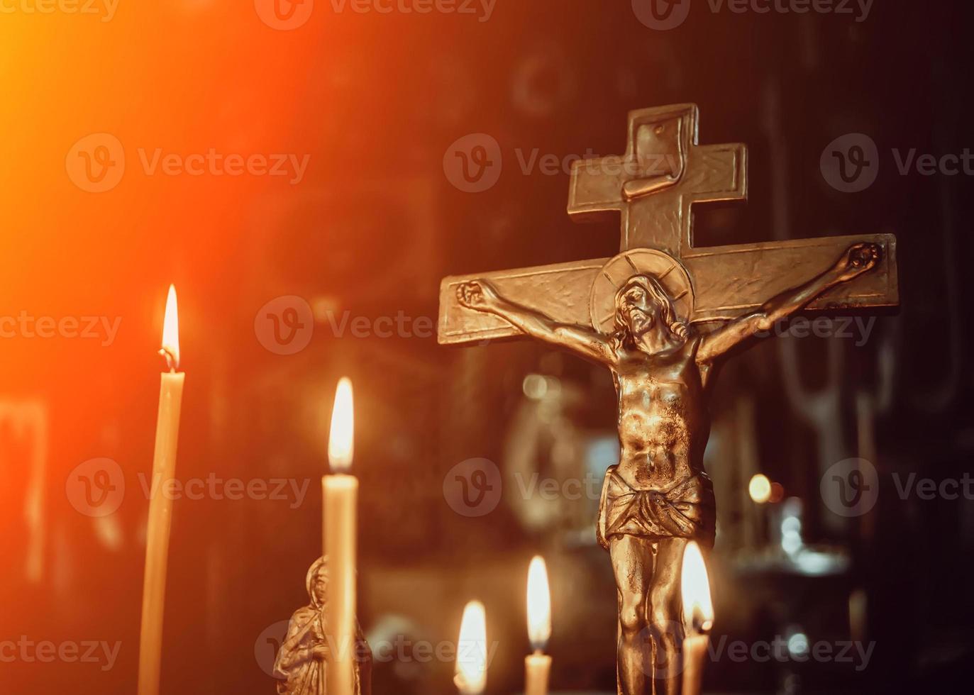 crucificação na igreja no fundo de velas foto