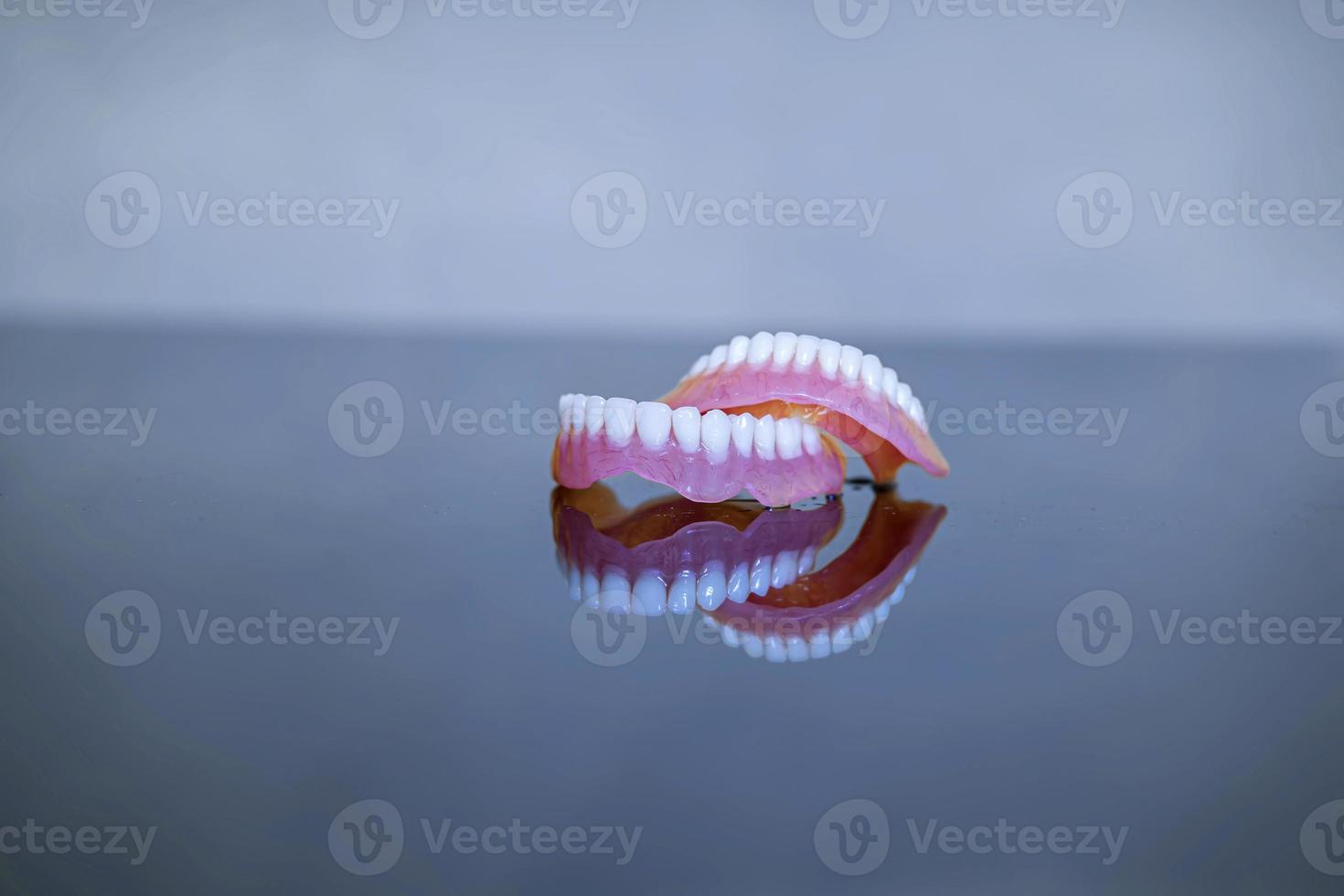 modelo de dentes para dentistas para explicar várias doenças ou problemas dentários. fundo cinza foto