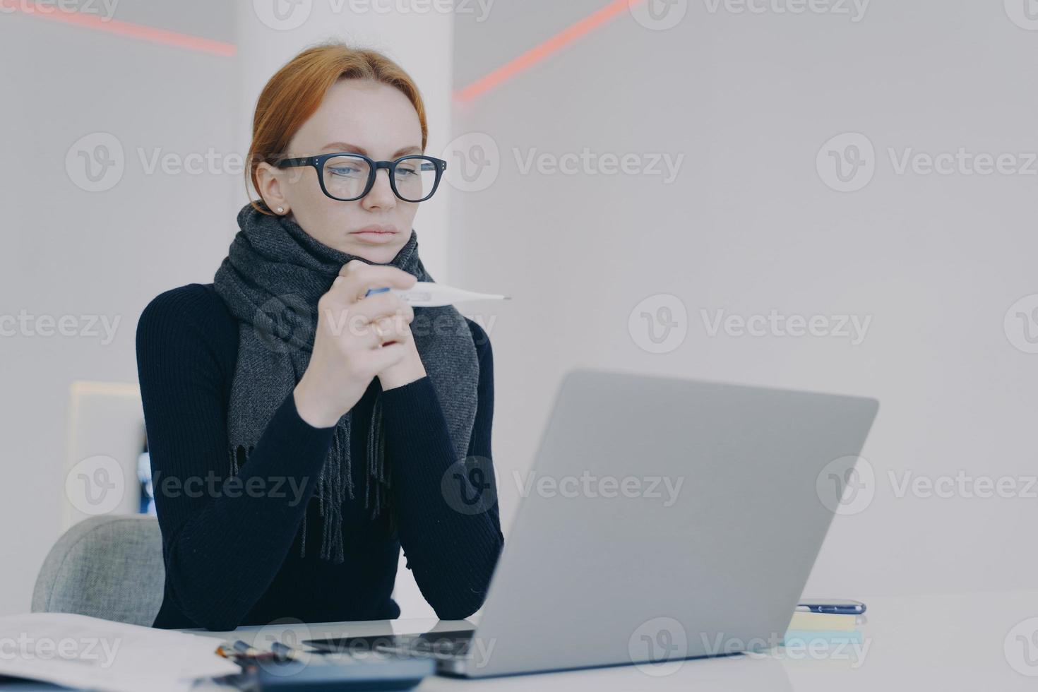 gerente está doente. jovem mulher branca de óculos tem alta temperatura. empresária doente. foto