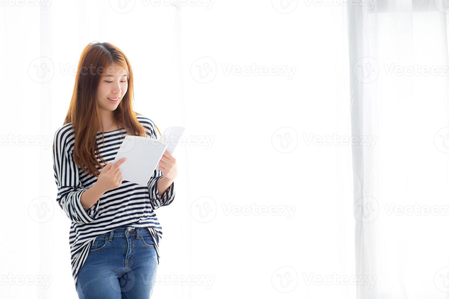 linda de retrato jovem mulher asiática relaxe em pé lendo livro no quarto em casa, literatura de estudo de menina, educação e conceito de estilo de vida. foto