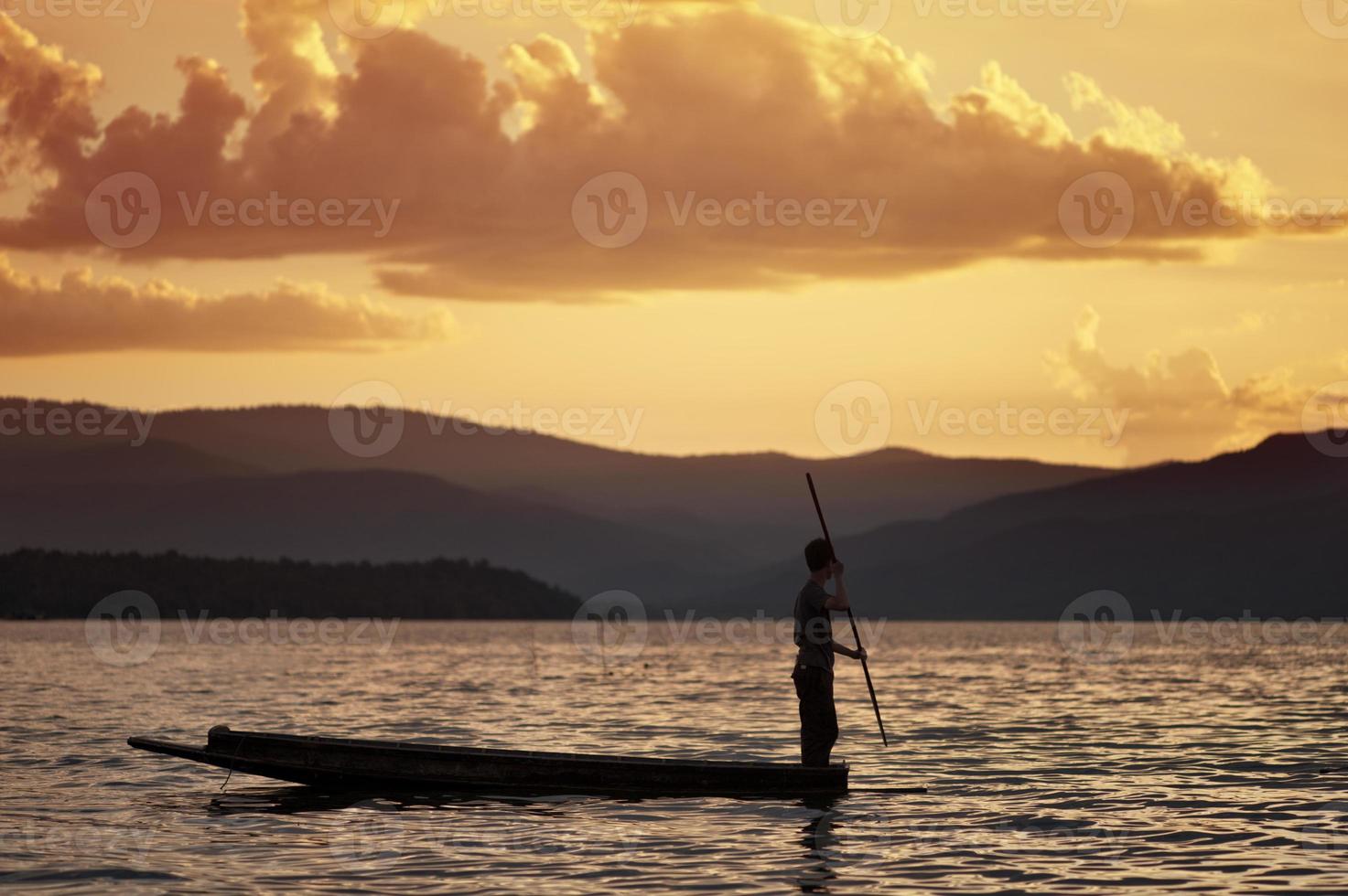 homem remando uma canoa tradicional foto