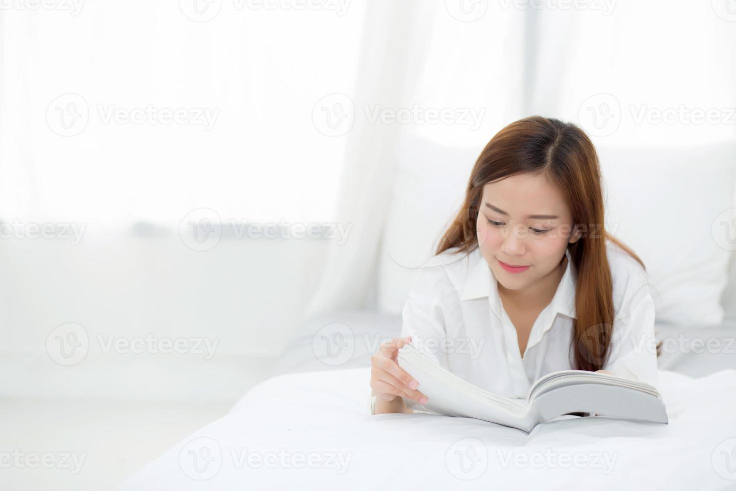 linda de retrato jovem mulher asiática relaxe mentindo lendo livro no quarto em casa, menina estudo literatura, educação e conceito de estilo de vida. foto