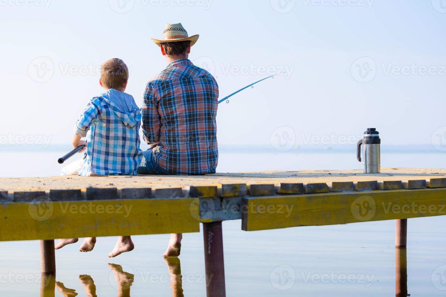 menino e seu pai pescando juntos foto