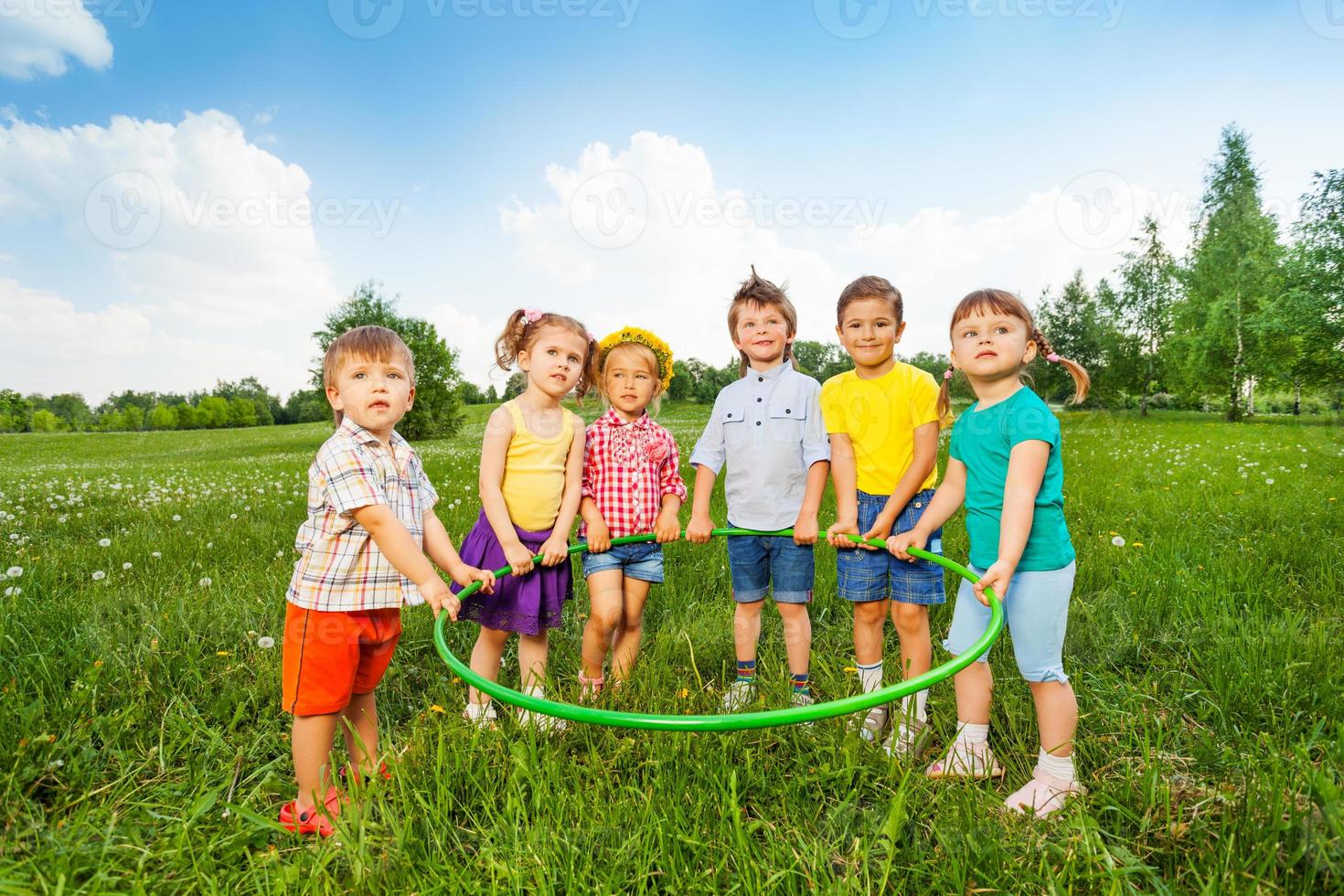 seis crianças engraçadas segurando um aro juntos foto