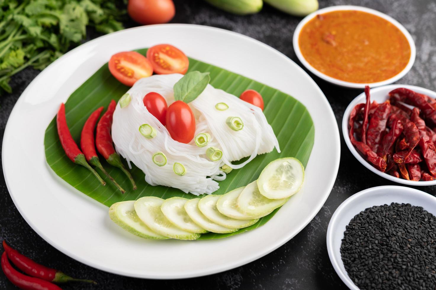 macarrão em uma folha de bananeira com legumes lindamente dispostos e acompanhamentos. comida tailandesa. foto
