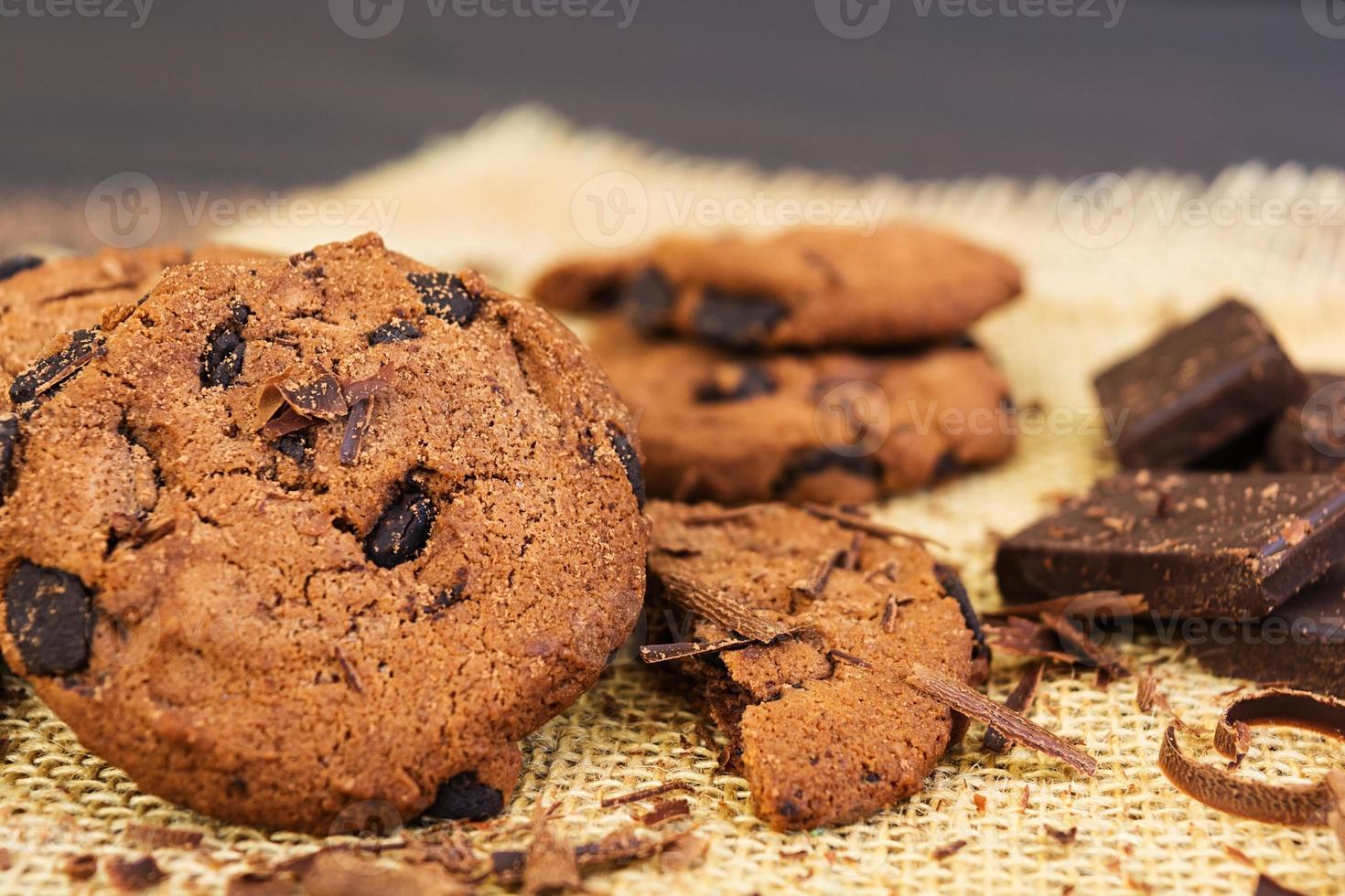 biscoitos com chocolate no fundo escuro de madeira foto