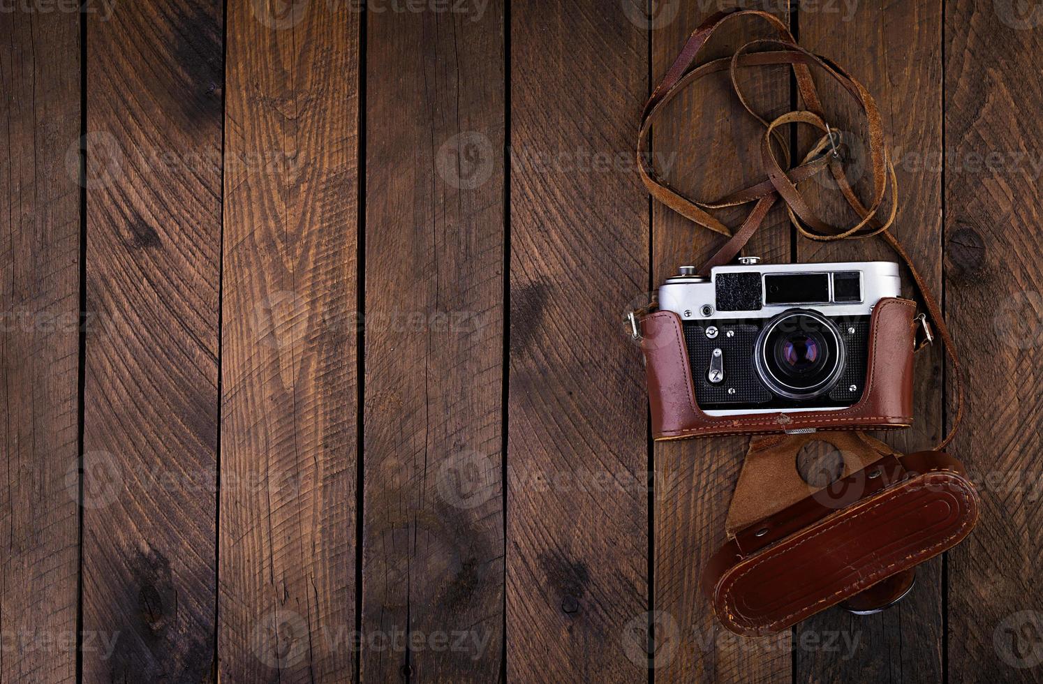 câmera antiga vintage em fundo de madeira rústica. vista do topo foto