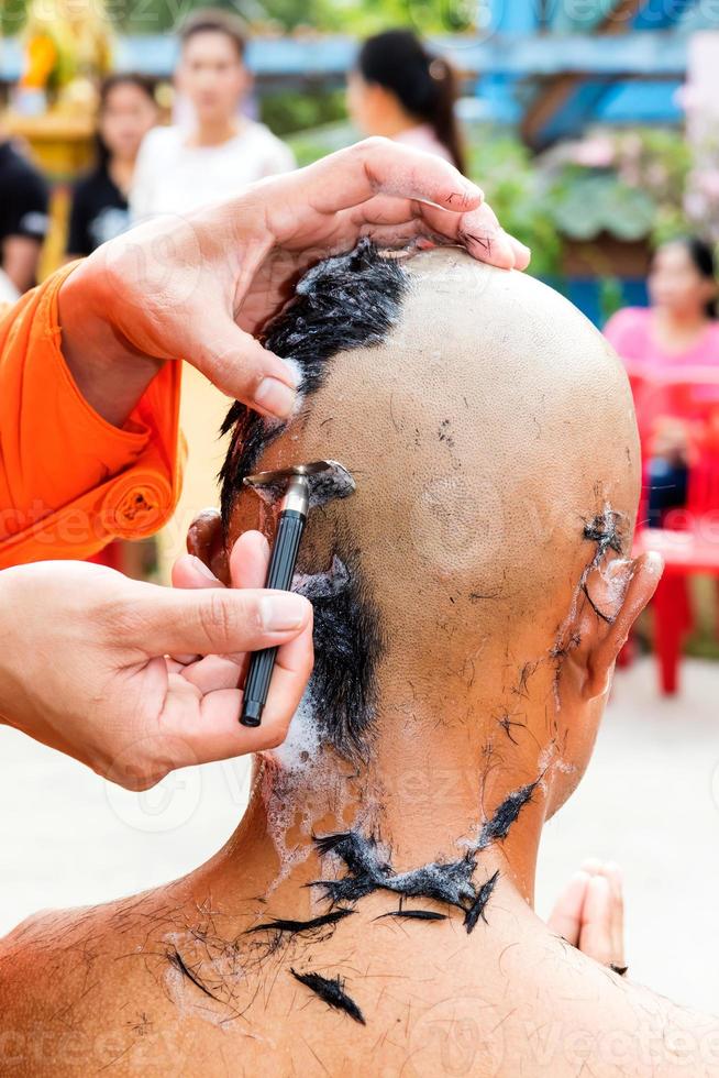 mãos de monge estão raspando cabeças. foto