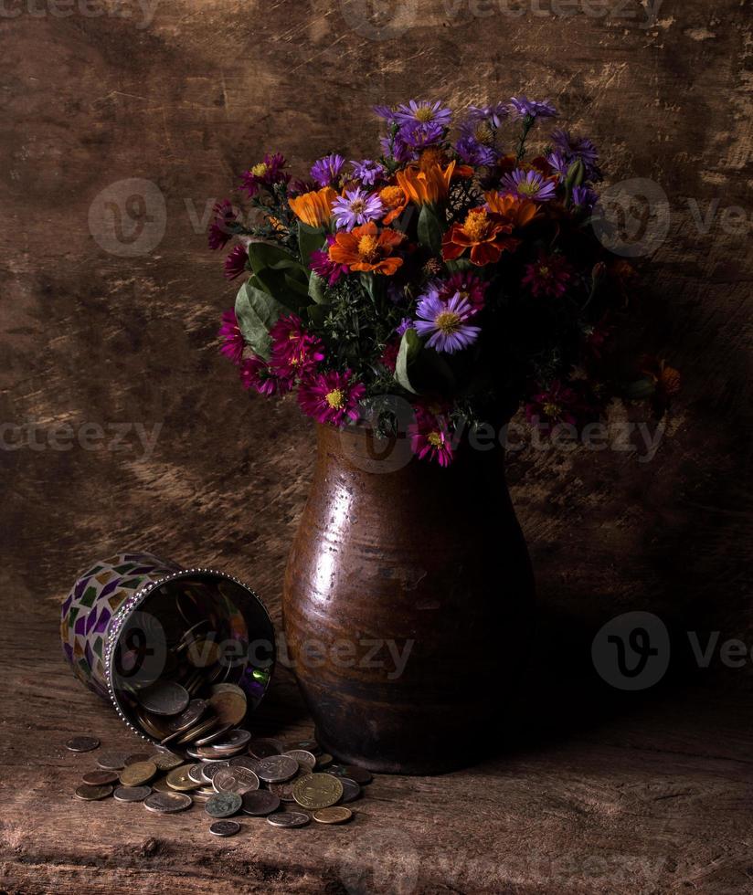 flores em vaso e pilha de moedas antigas foto