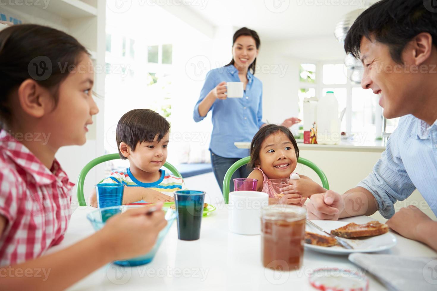 família asiática tomando café juntos na cozinha foto